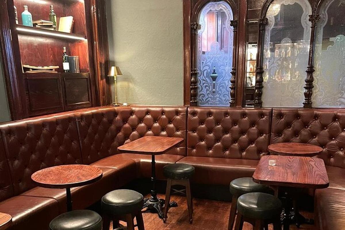bar s hnědou koženou pohovkou a stoličkami