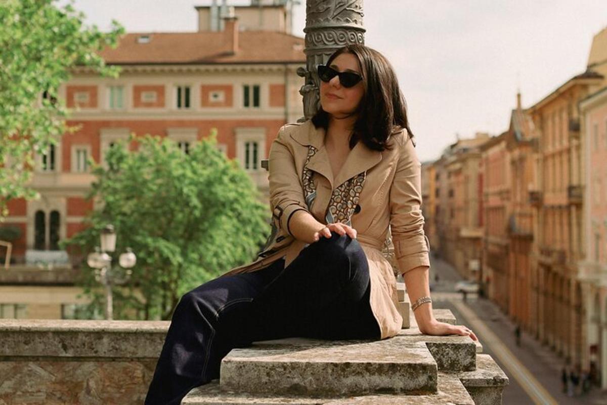 uma mulher sentada em um muro em uma cidade