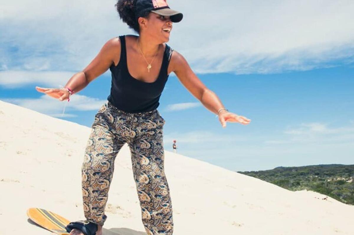 žena stojící na snowboardu v písku