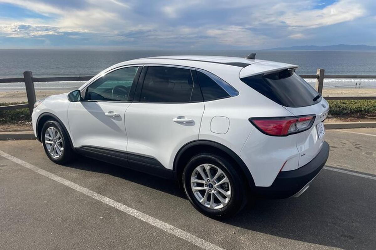 bílé auto zaparkované na parkovišti poblíž oceánu