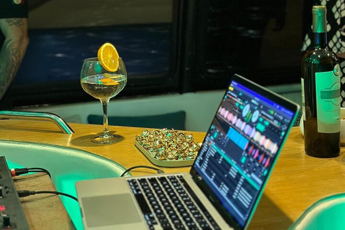 a laptop computer sitting on a table with a glass of wine