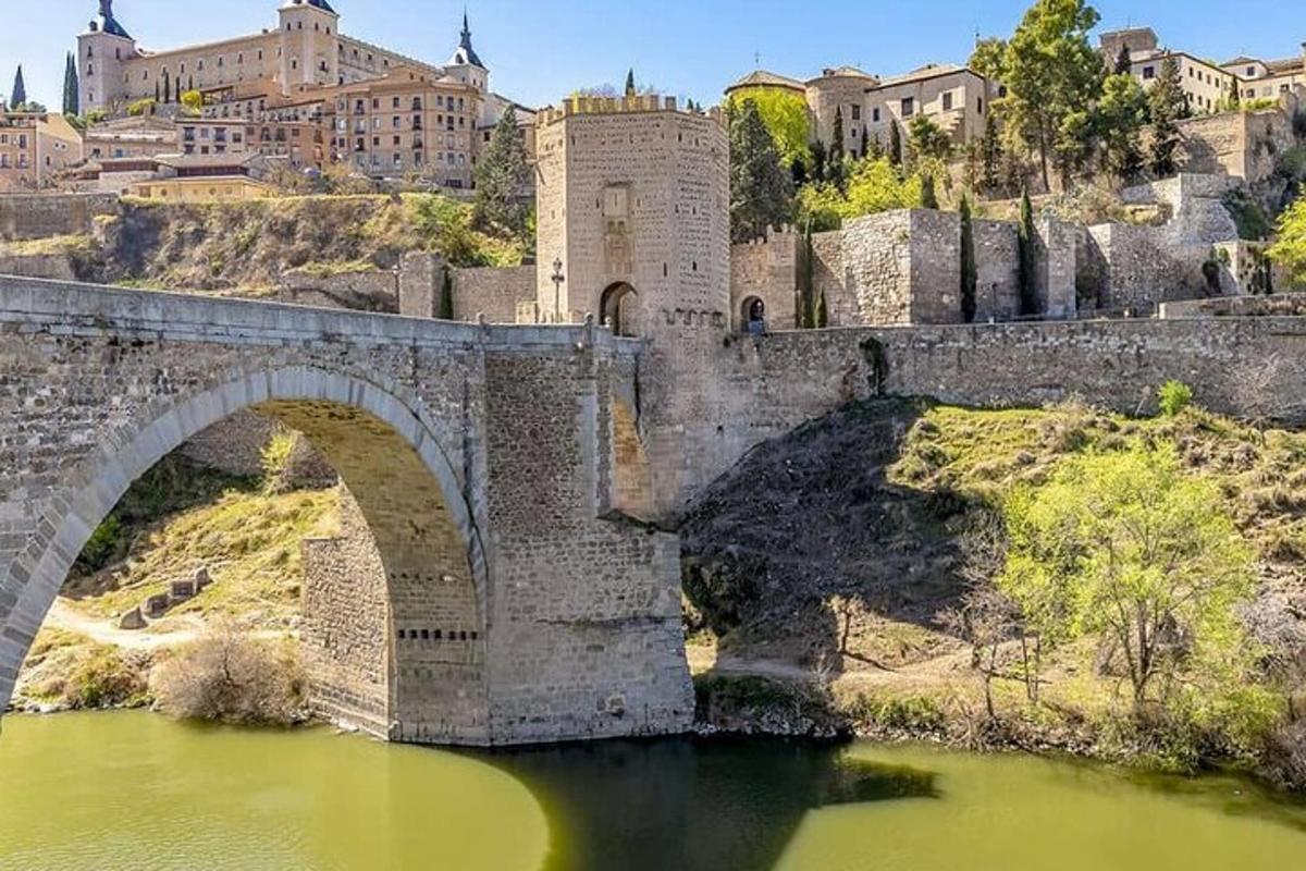 Un viejo puente sobre un río con edificios al fondo.