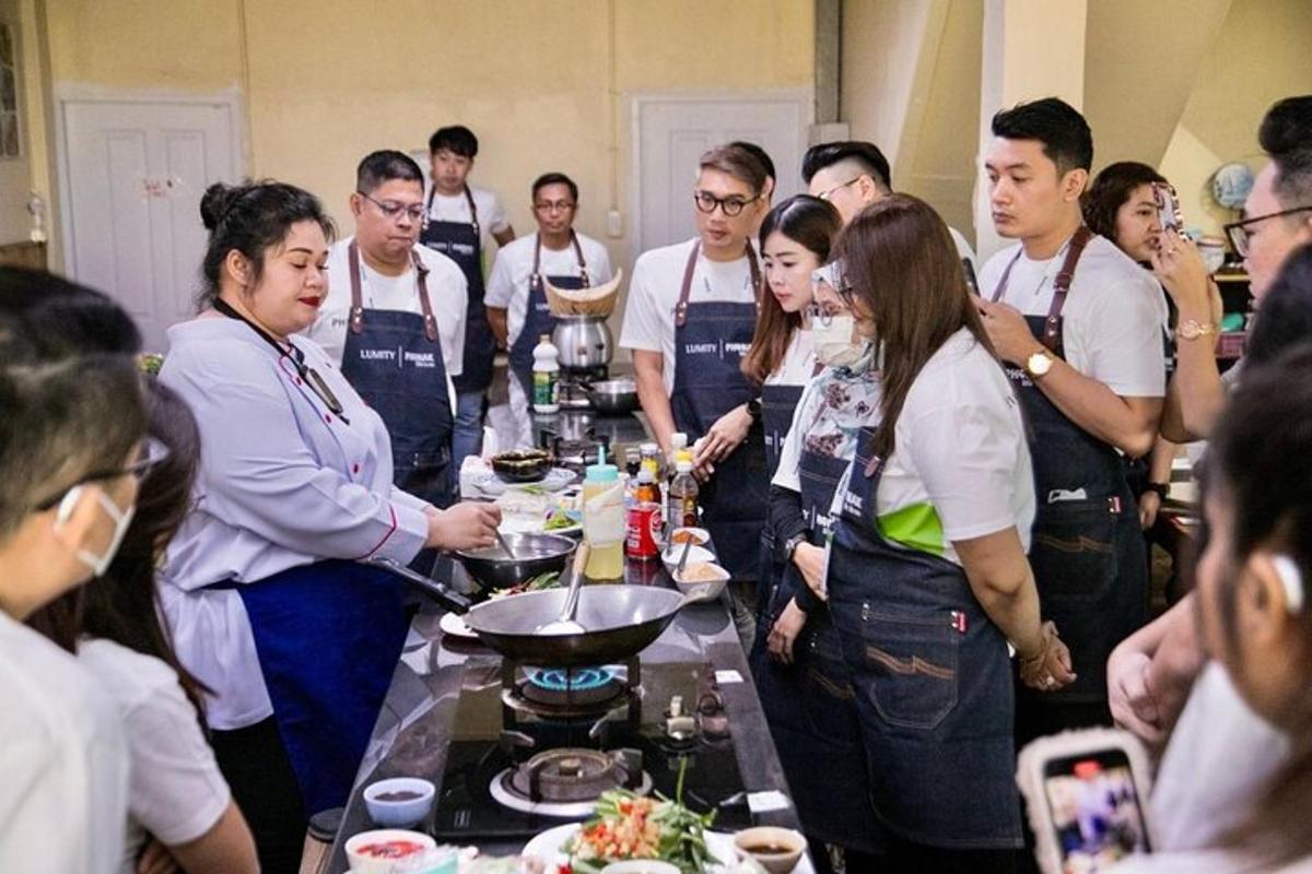 a group of people standing around a table with food
