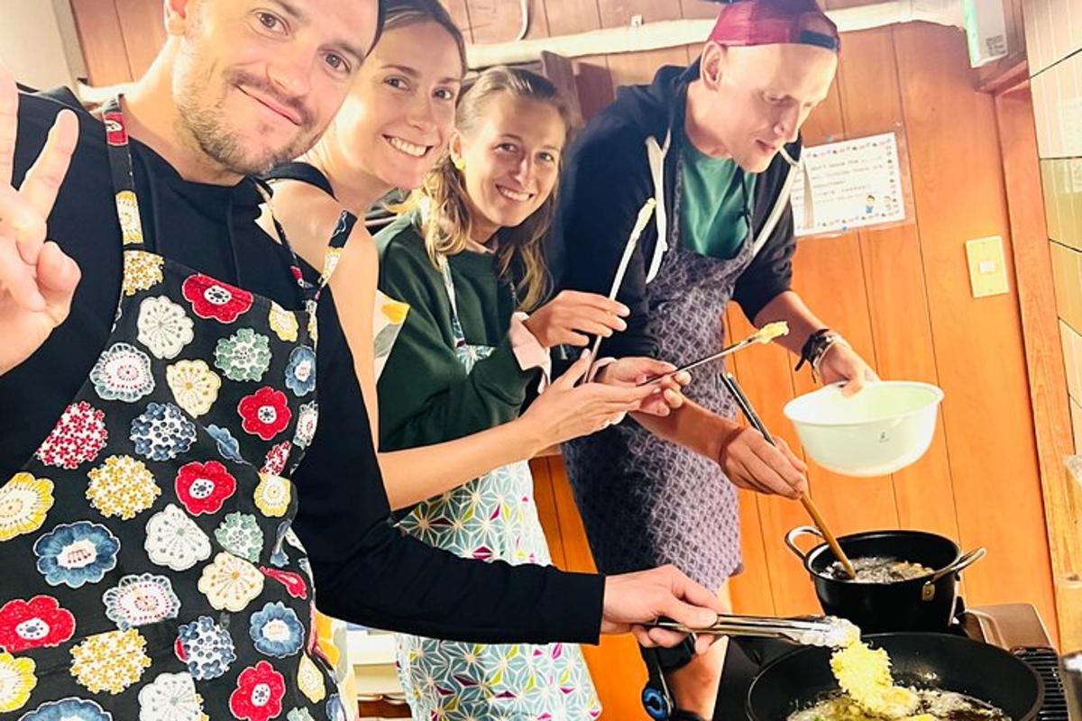 skupina lidí stojících v kuchyni a připravujících jídlo