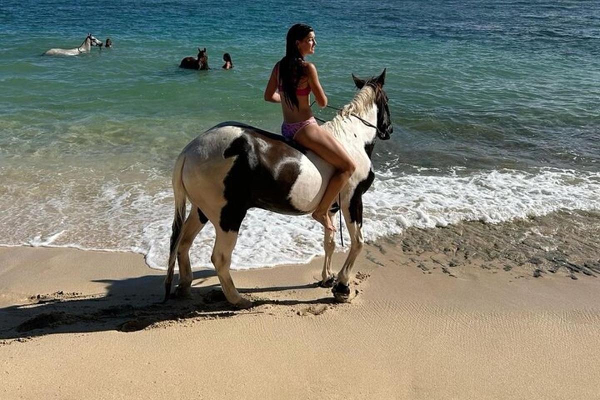 una giovane ragazza a cavallo sulla spiaggia