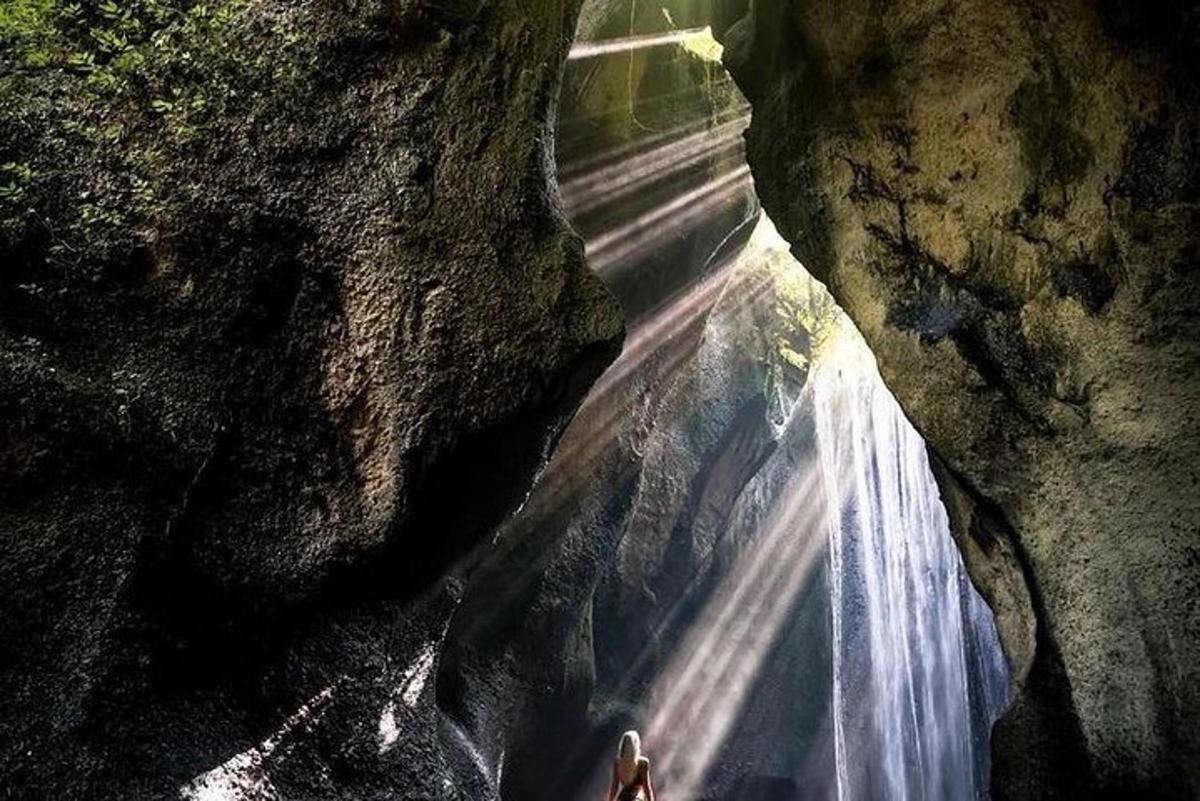 una persona è in piedi davanti a una cascata