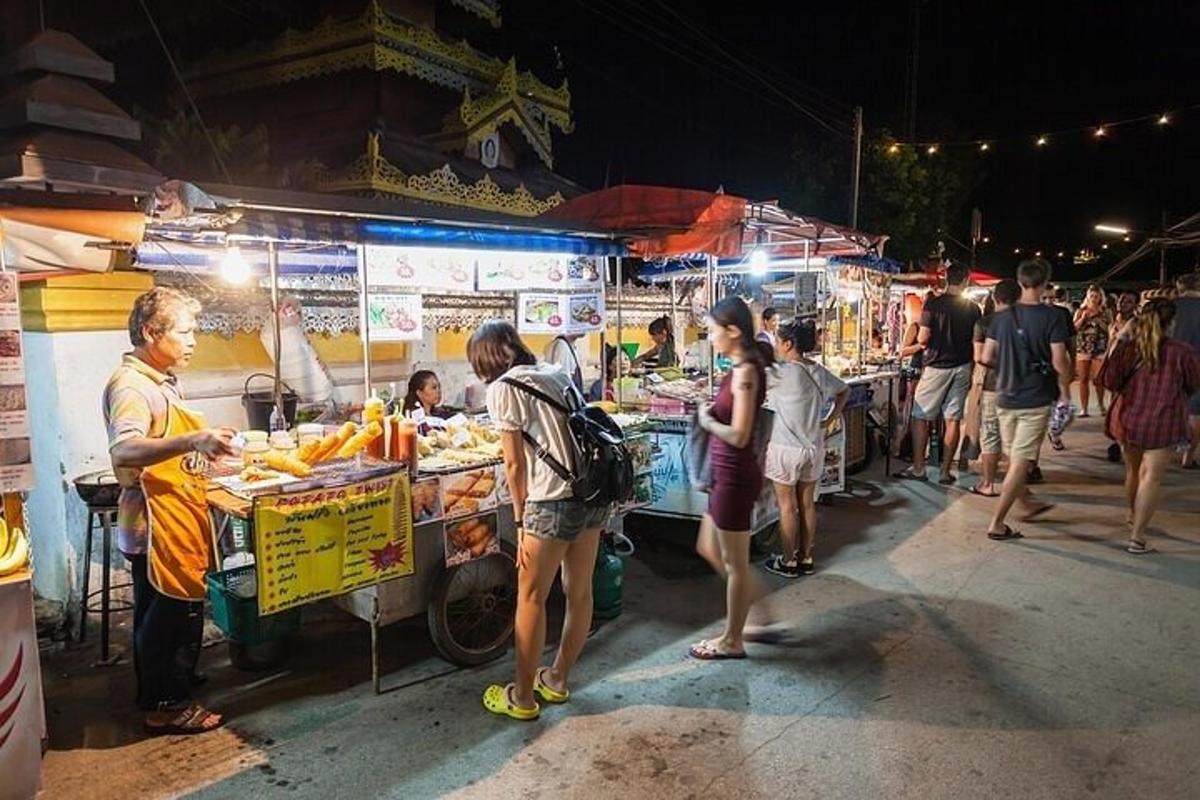 夜、屋台の周りに立っている人々のグループ