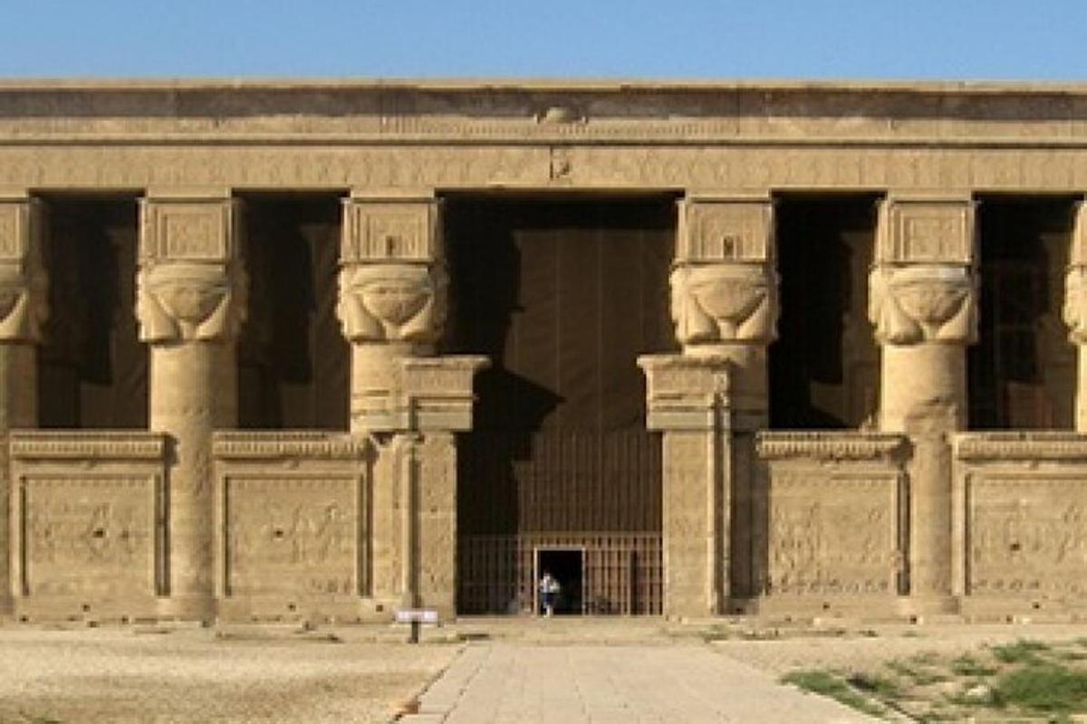 مبنى حجري كبير به أعمدة وشخص يقف في المدخل