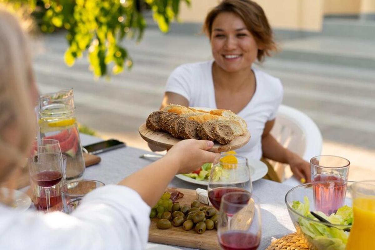moteris, sėdinti prie stalo su lėkšte maisto
