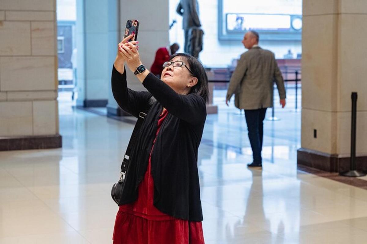 a woman taking a picture with her cell phone in a building