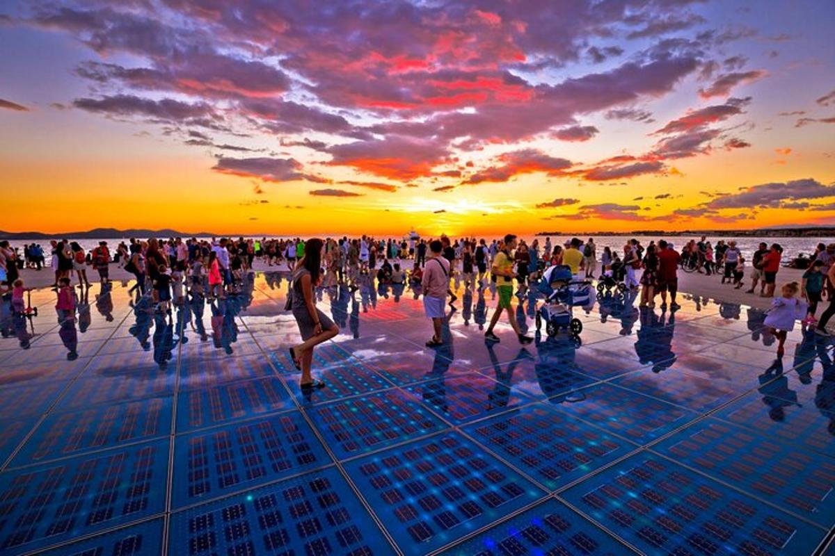 un folto gruppo di persone che camminano al tramonto