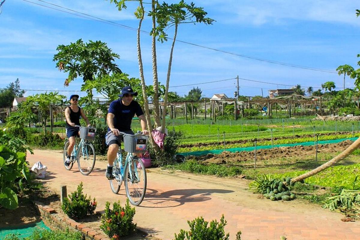 two people riding bikes down a dirt road