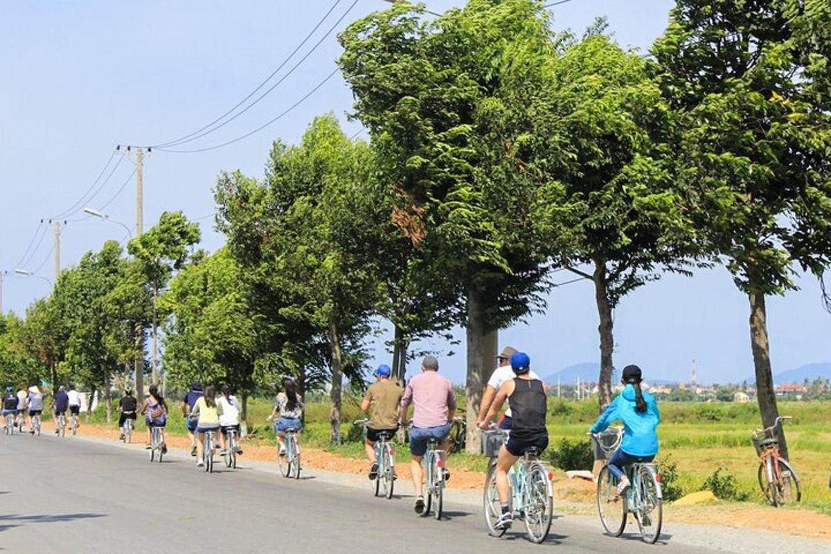 un gruppo di persone che vanno in bicicletta lungo una strada