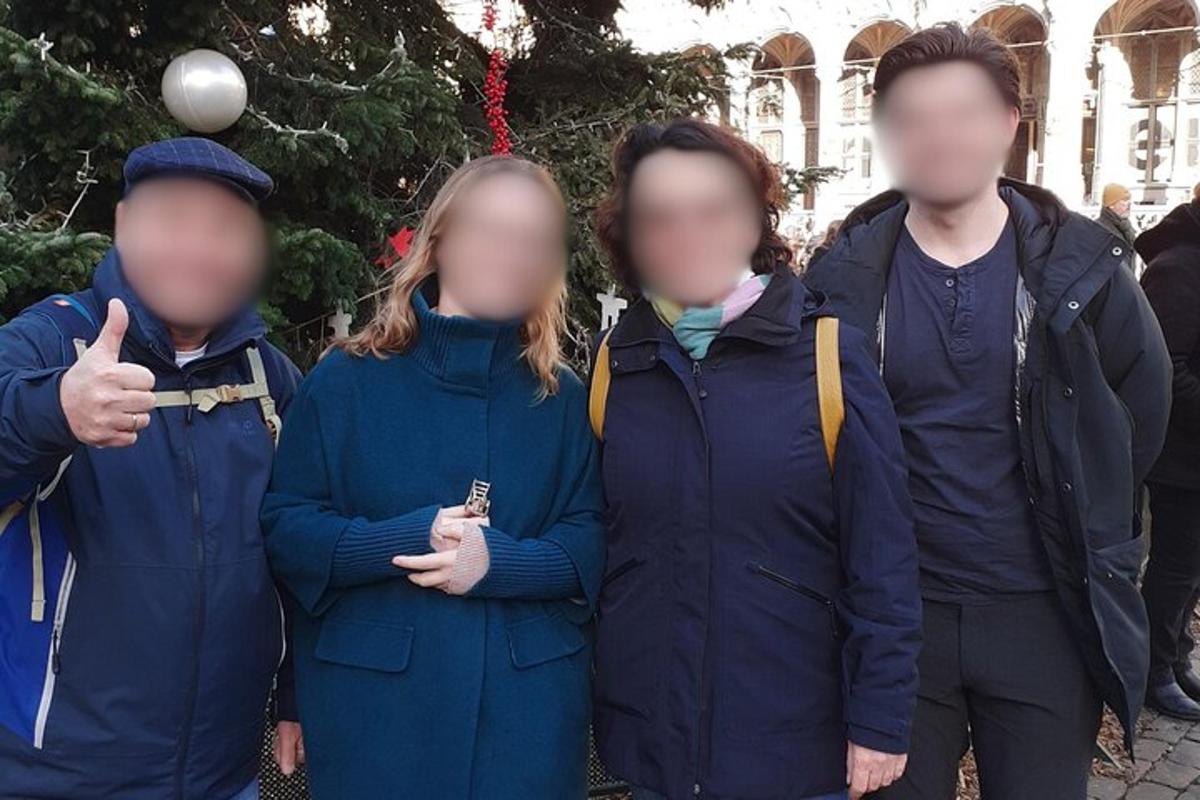 a group of people standing in front of a christmas tree