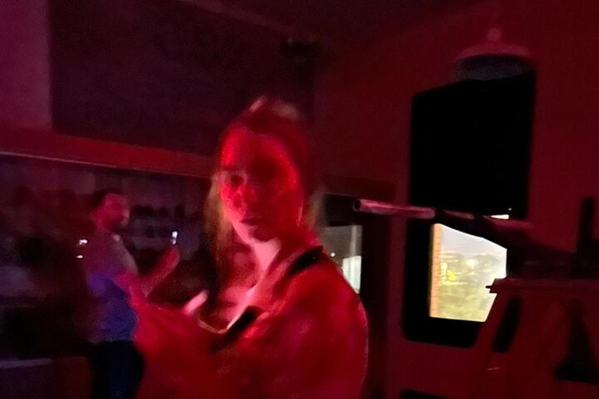naine seisab pimedas toas punaste tuledega