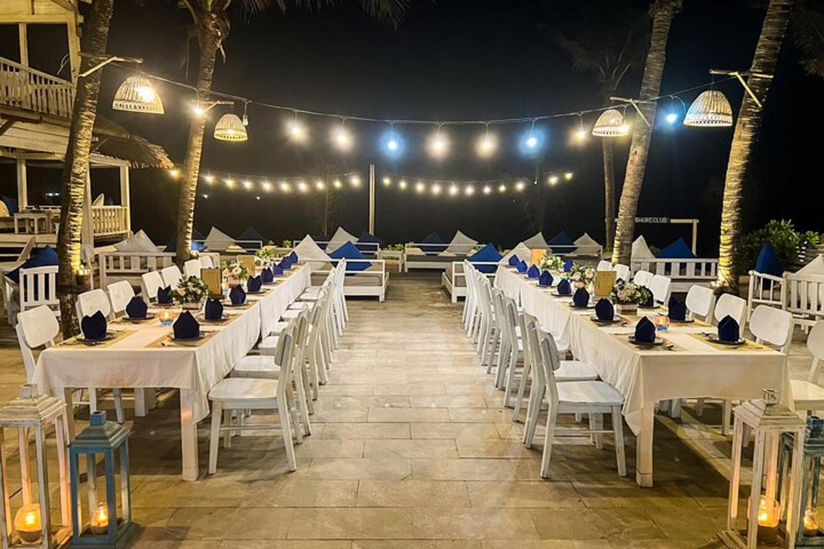 une rangée de tables avec des chaises blanches et des lumières