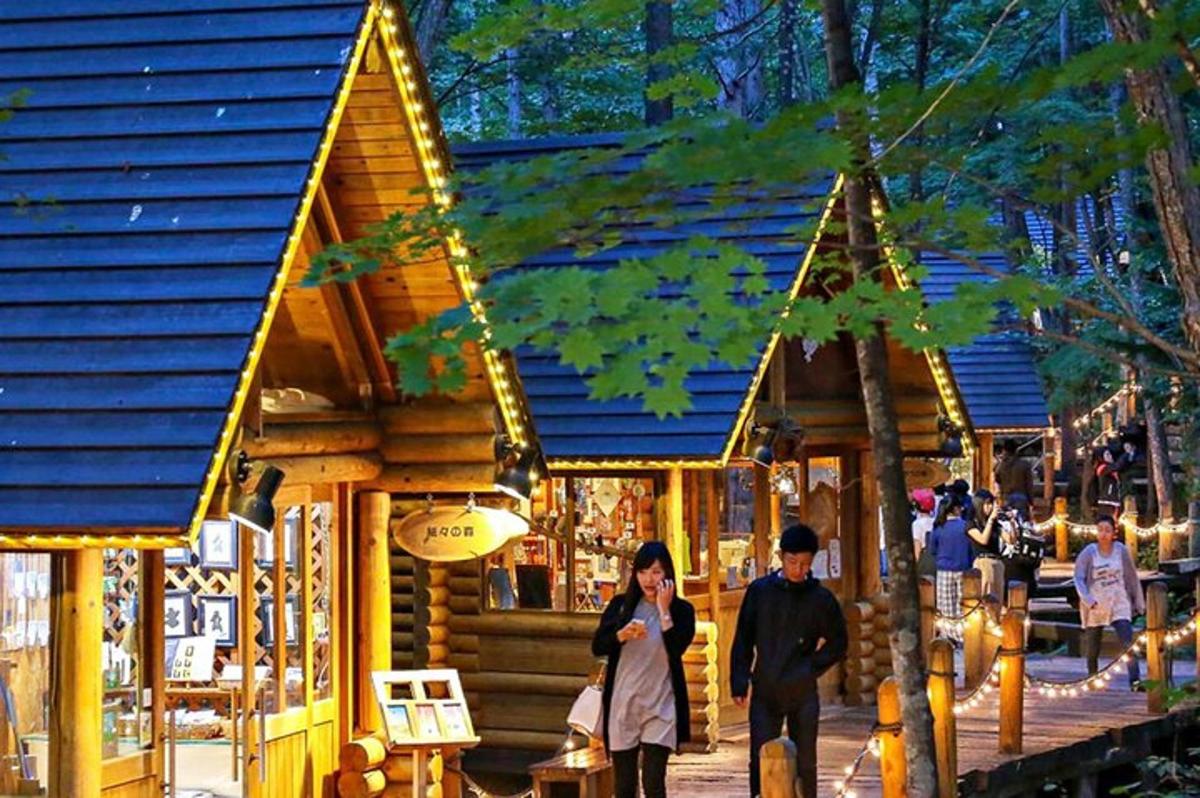 a man and woman walking in front of a log building