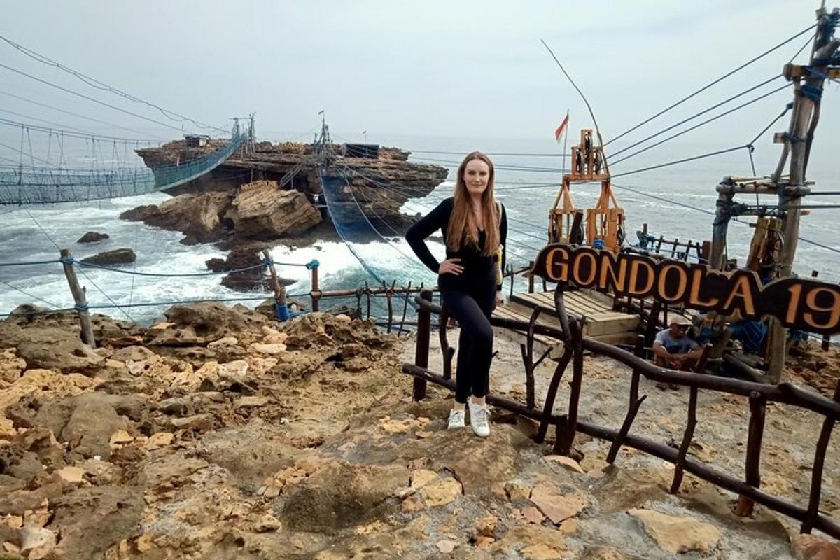 uma mulher sentada em uma cerca perto do oceano