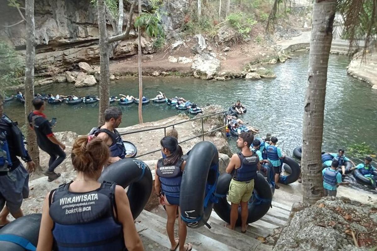 isang grupo ng mga tao na nagba-rafting sa isang ilog sa mga tubo