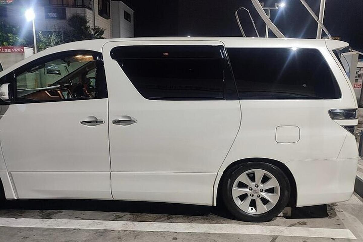 Una camioneta blanca estacionada en un estacionamiento por la noche