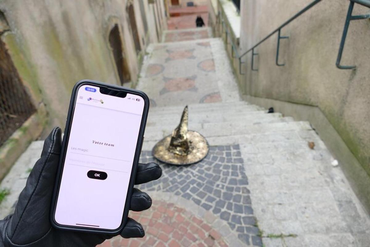 osoba držící mobilní telefon před ulicí