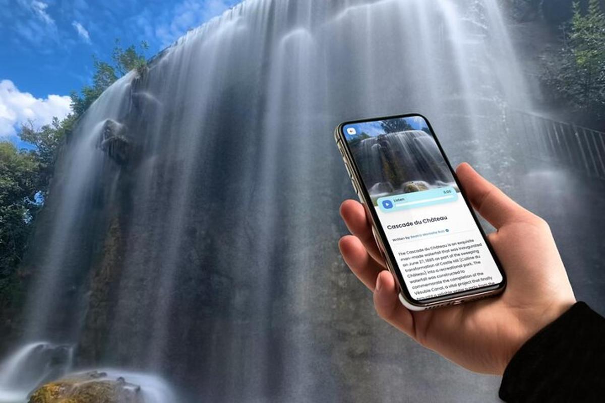 osoba držící mobilní telefon před vodopádem