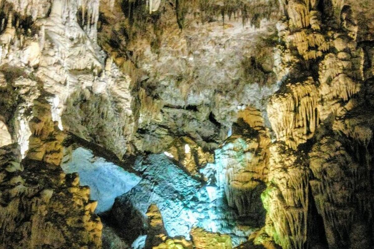 a painting of a cave with a river in it