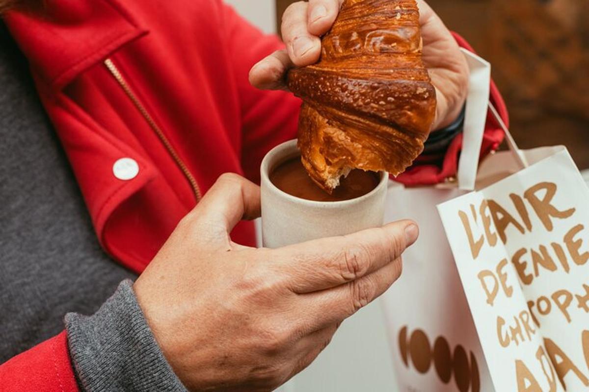 una persona sosteniendo una taza de café y un pastel