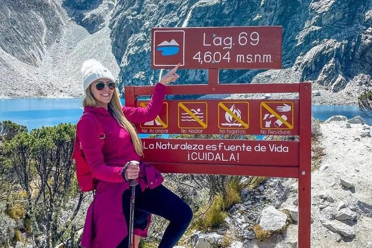 a woman standing next to a sign on a mountain