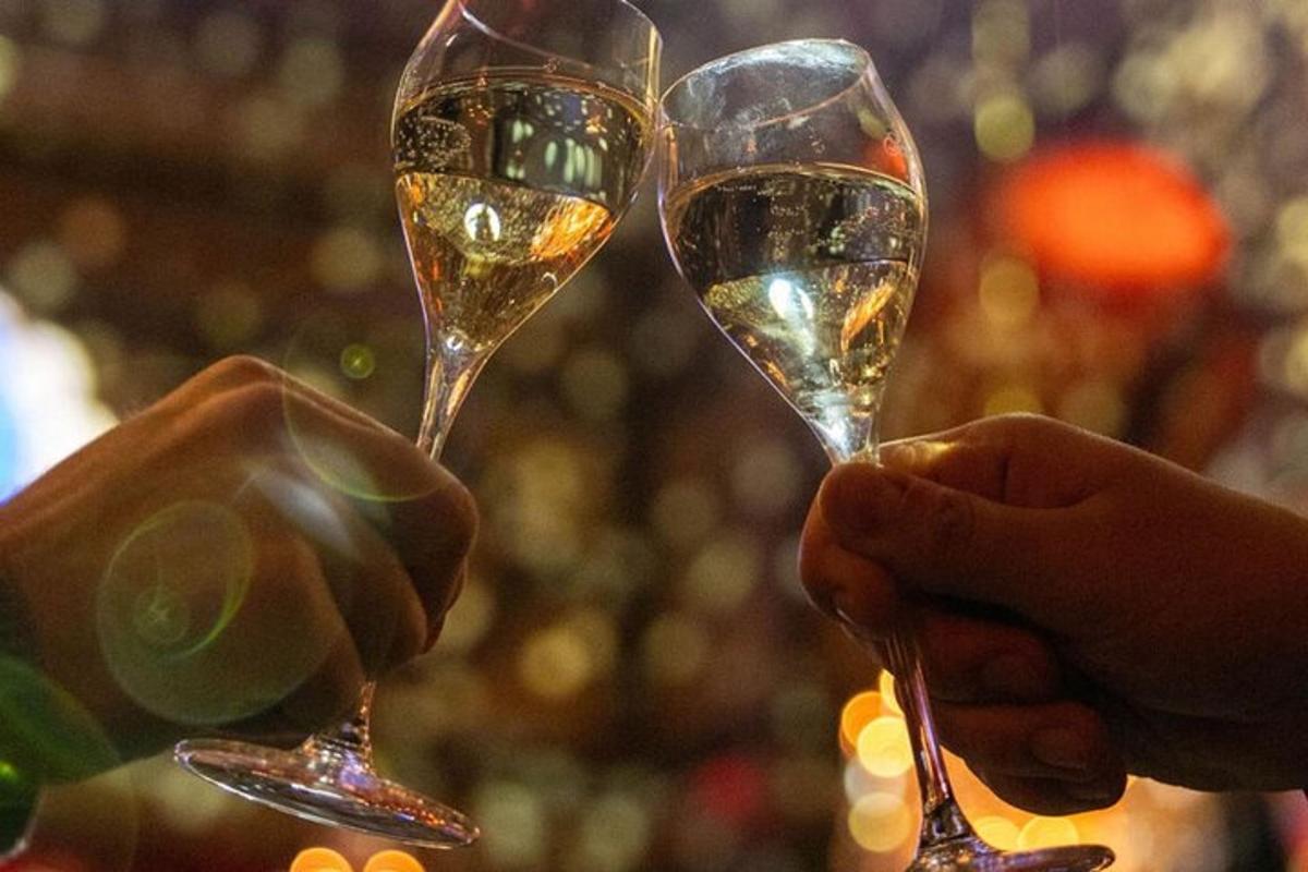 hai người đang cầm ly rượu vang trắng