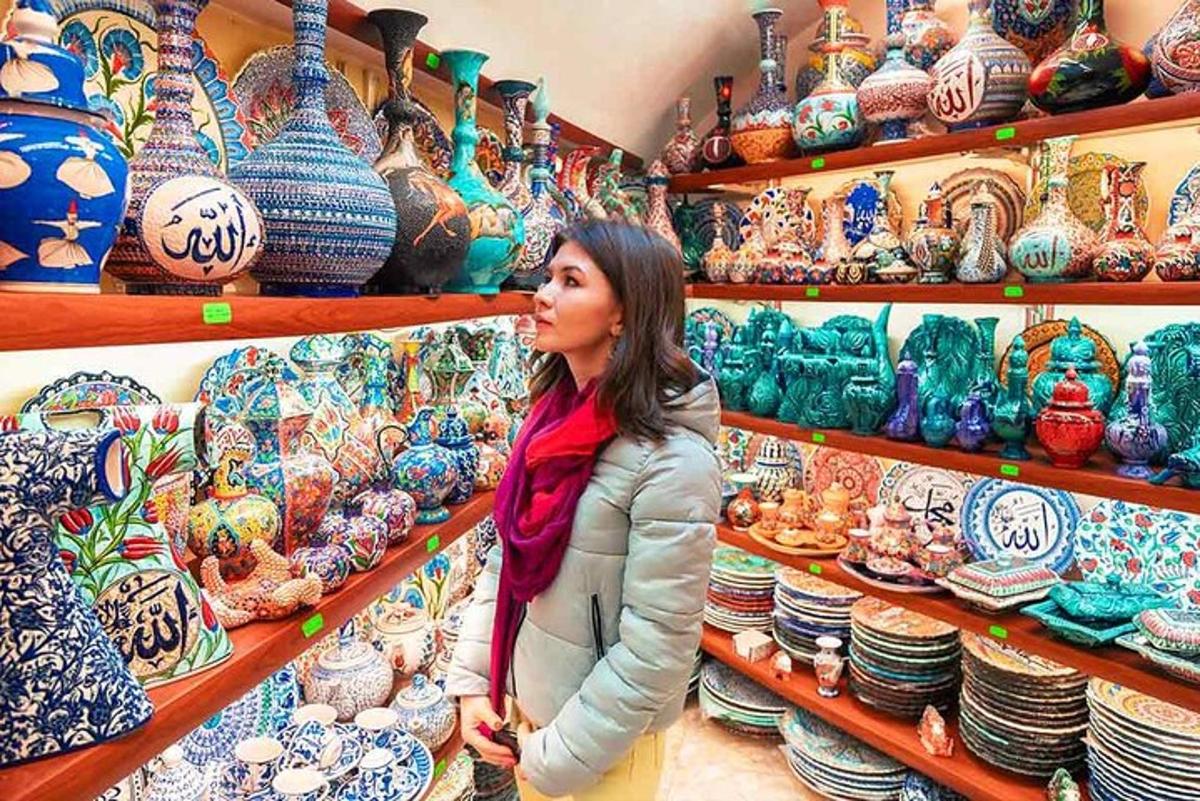 una donna in piedi davanti a una mostra di ceramiche