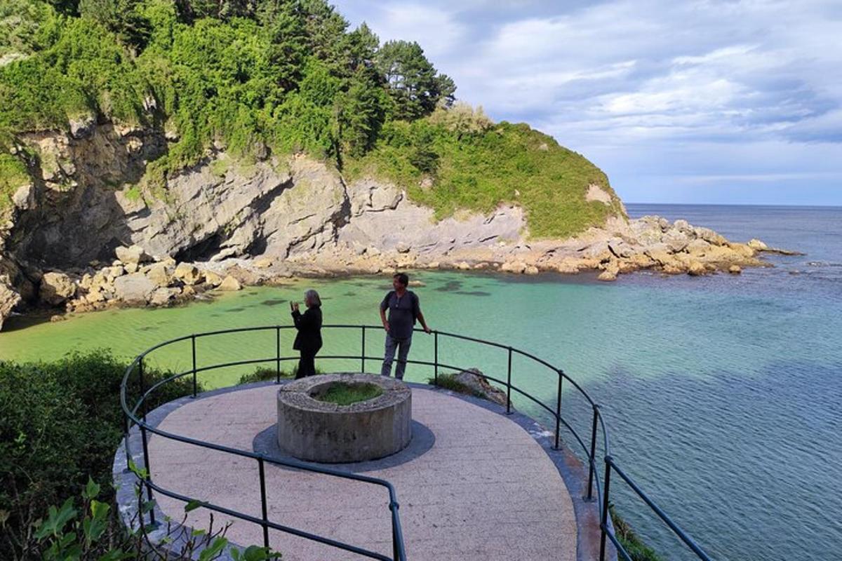 two people standing on a platform looking at the ocean