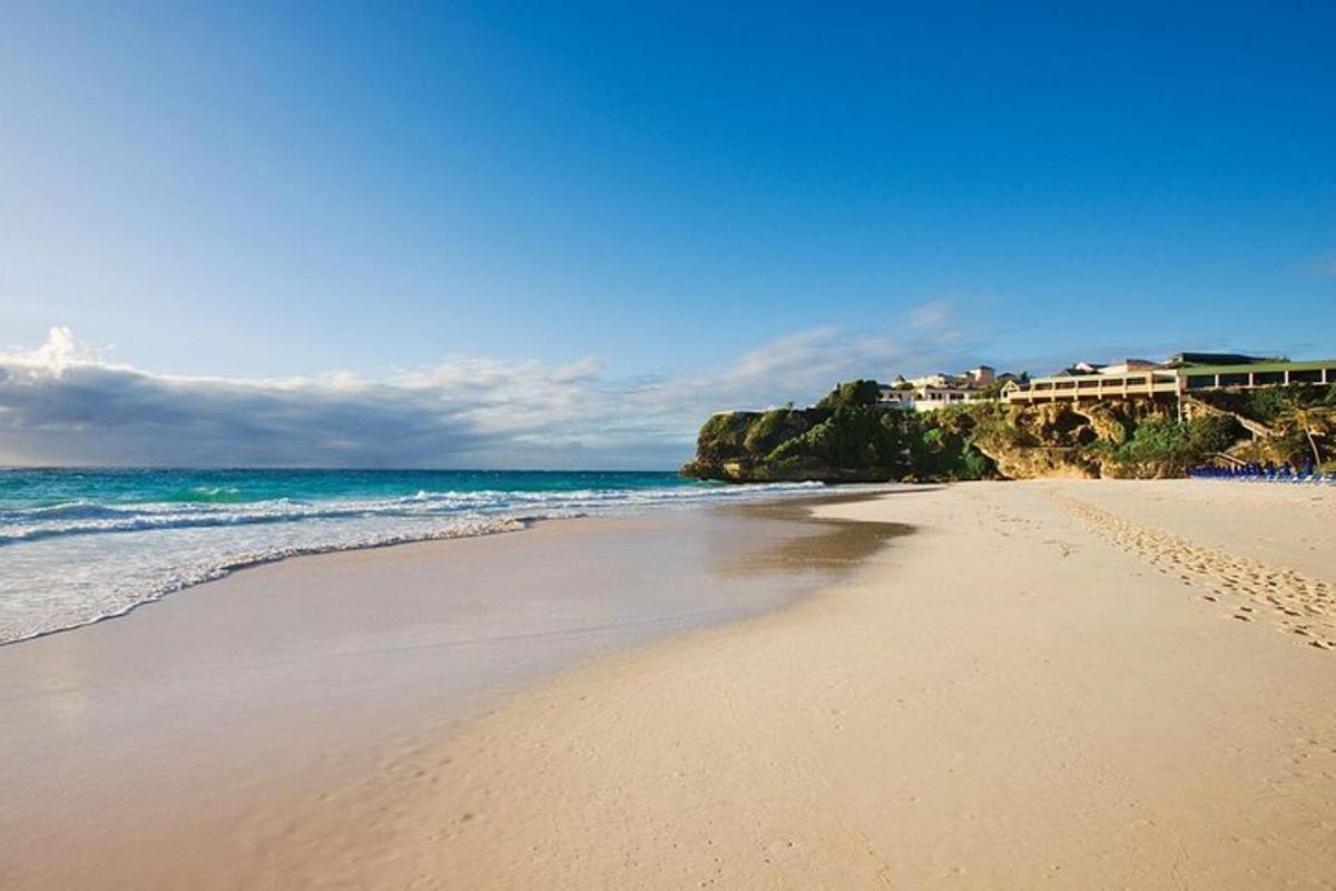 a sandy beach with the ocean and buildings in the background