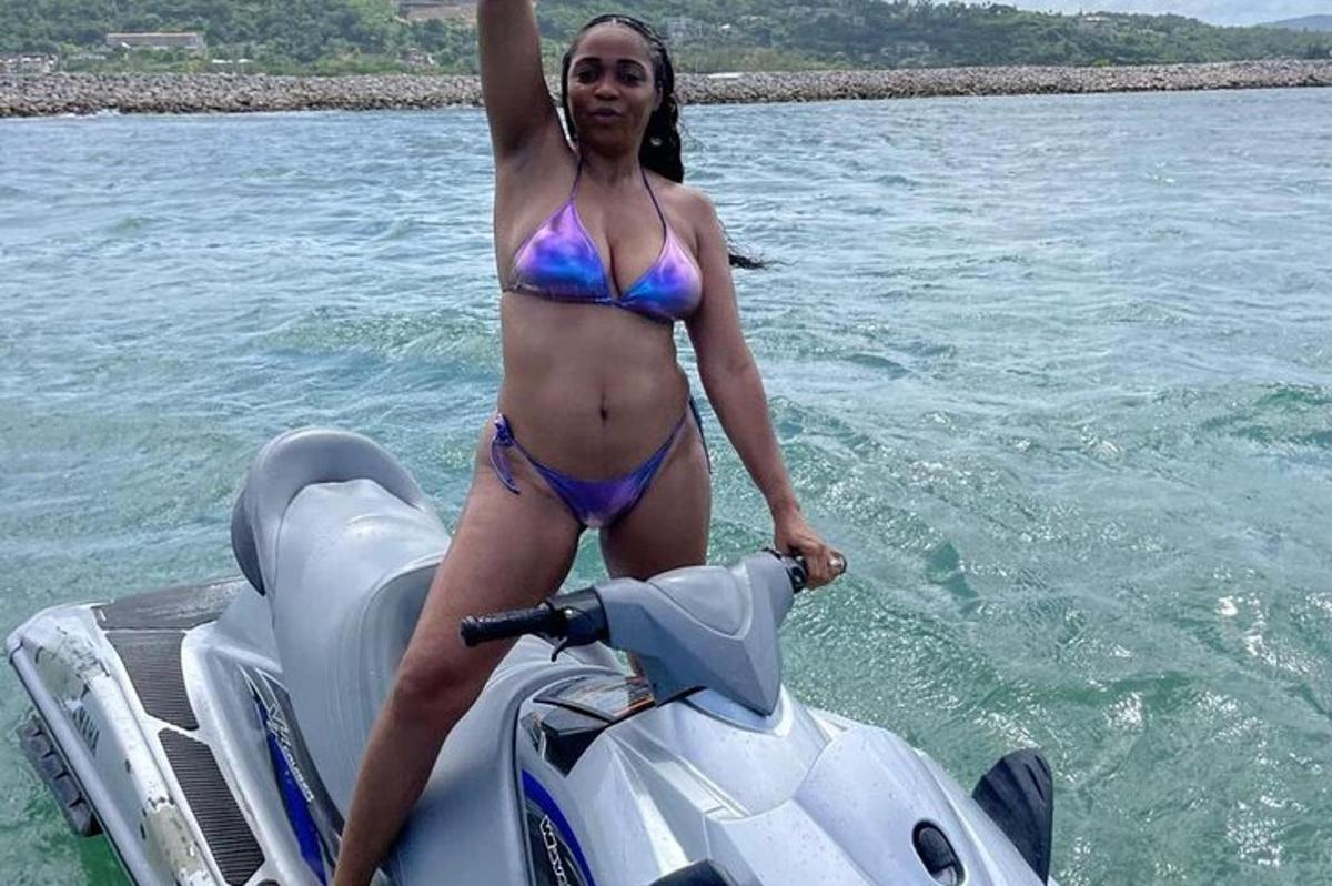 una donna in bikini in piedi su uno scooter