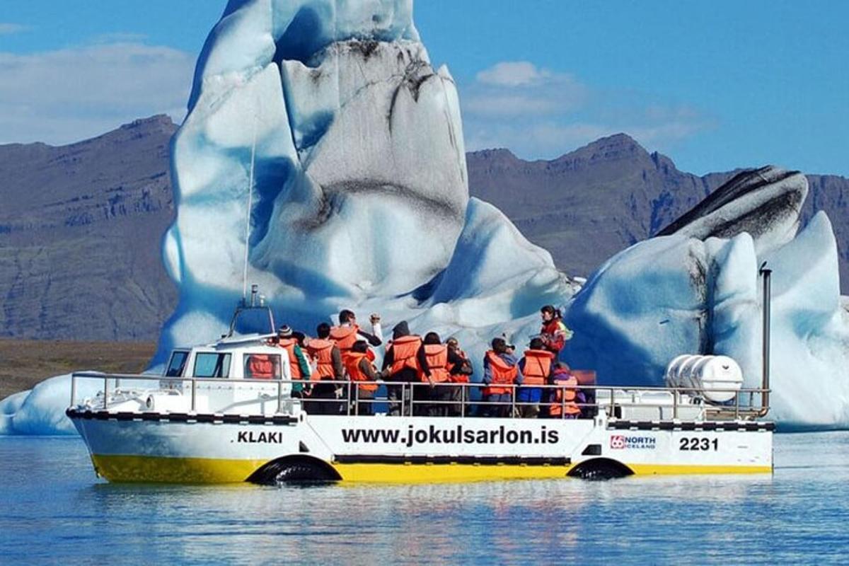 a group of people on a boat in front of an iceberg