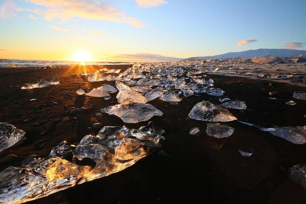 un grupo de rocas en una playa al atardecer