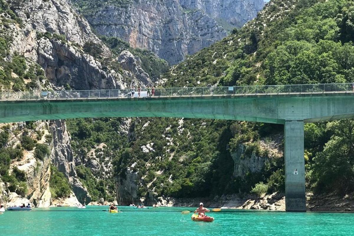 a bridge over a river with people kayaking under it