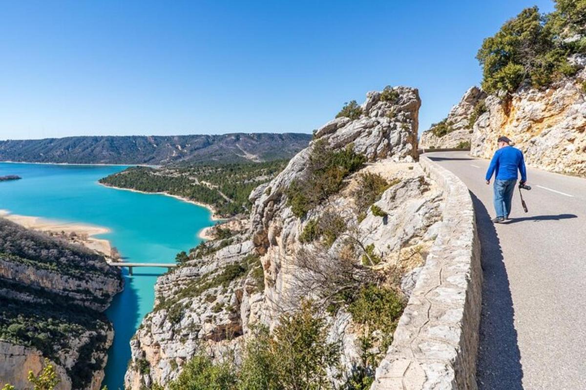 a man walking on a road next to a cliff