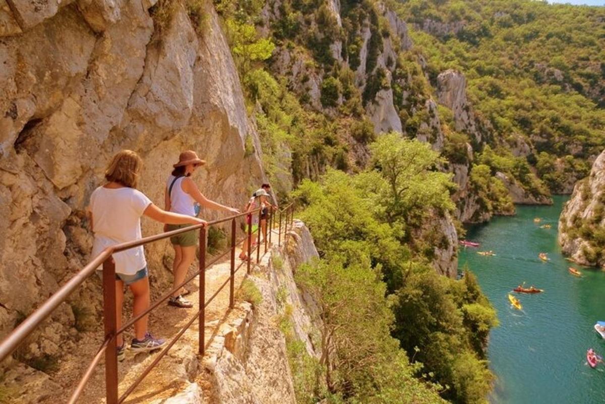two people standing on a railing overlooking a river
