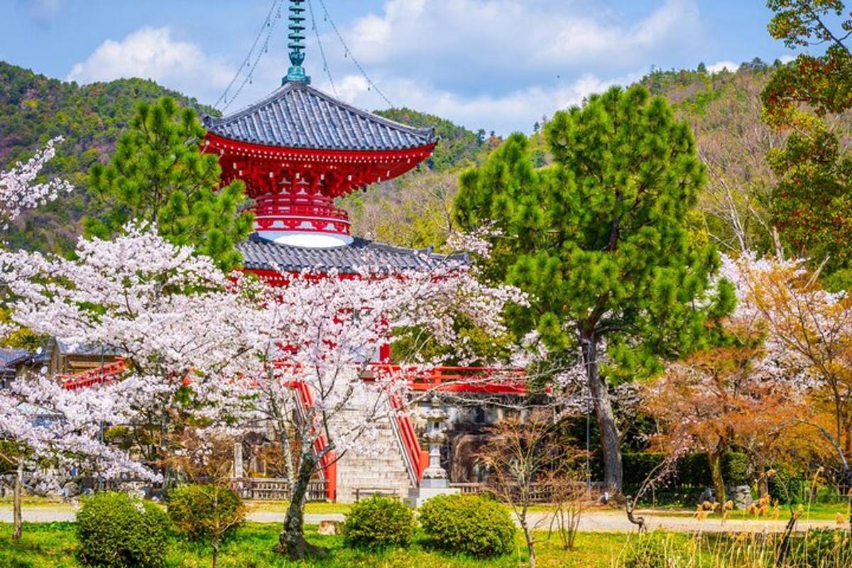 a red pagoda in a park with flowering trees