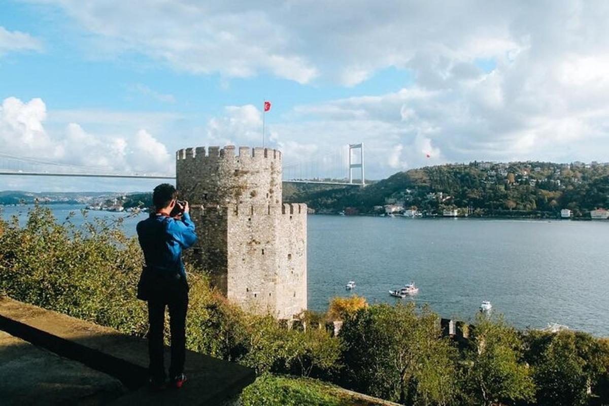 osoba fotící hrad u vody