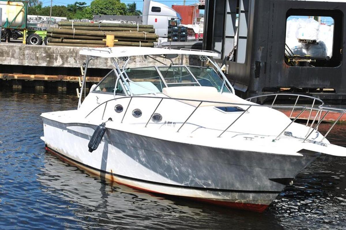 a white boat is docked in the water