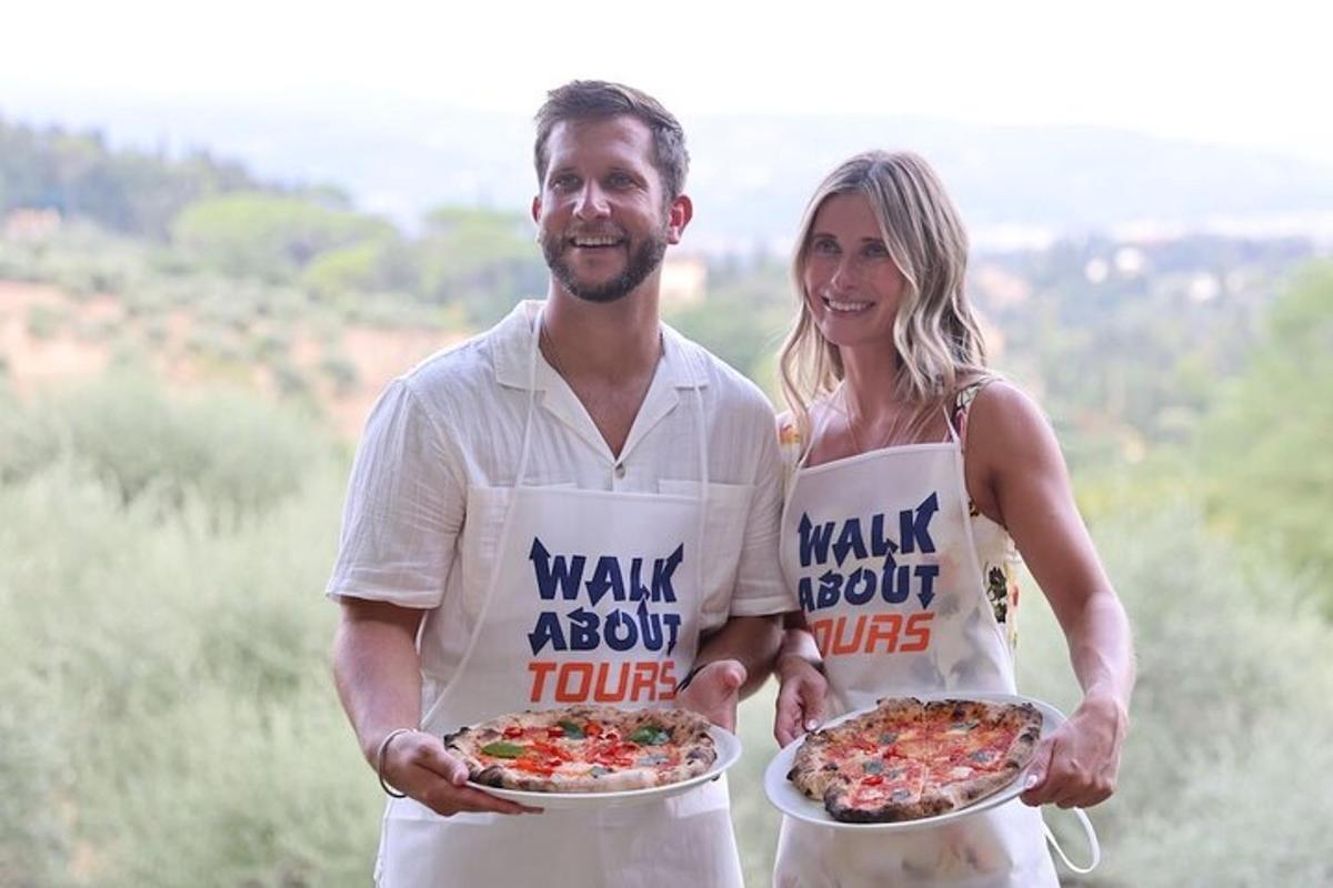 un uomo e una donna che indossano grembiuli e tengono in mano delle pizze
