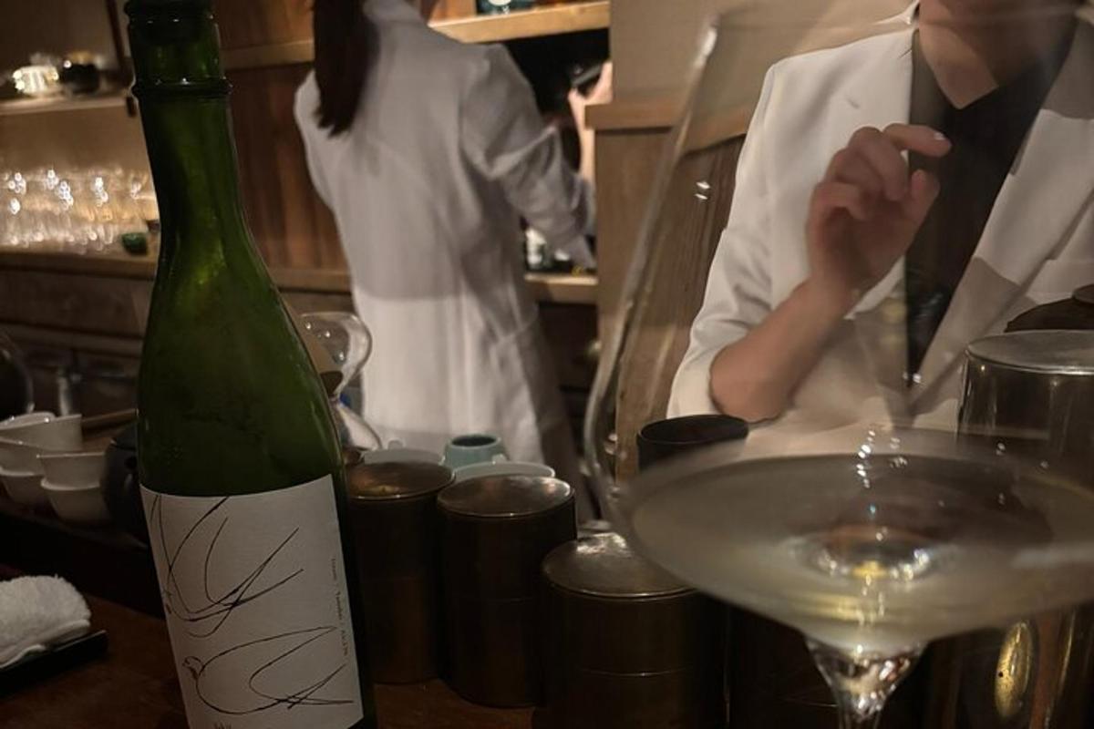 oseba, ki stoji v kuhinji s steklenico vina