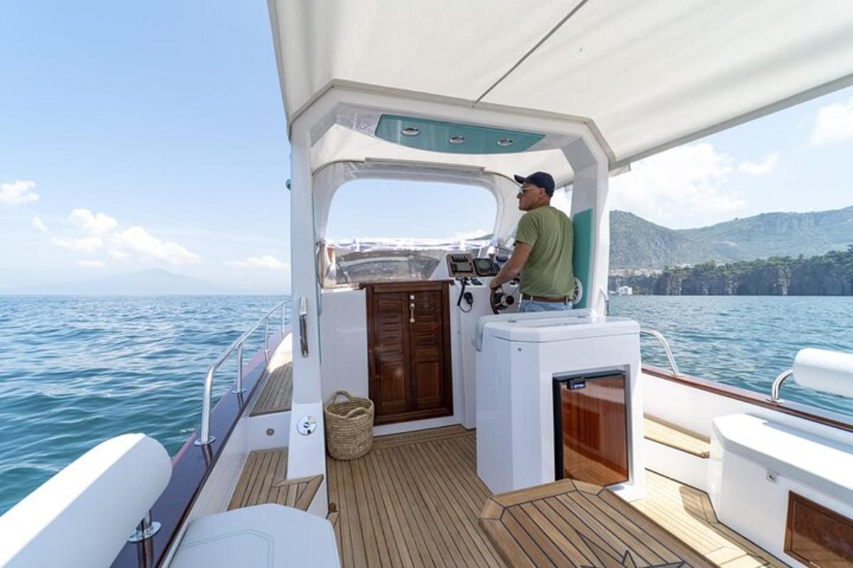 a man standing on the back of a boat in the water