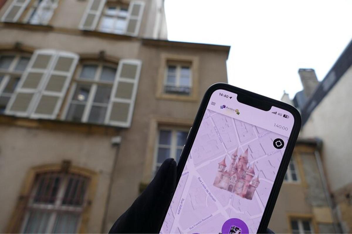 uma pessoa segurando um celular em frente a um prédio