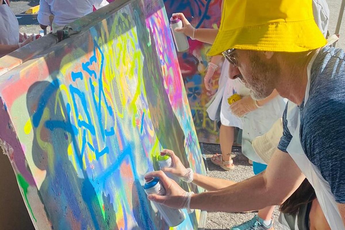 um homem com um chapéu amarelo pintando uma tela