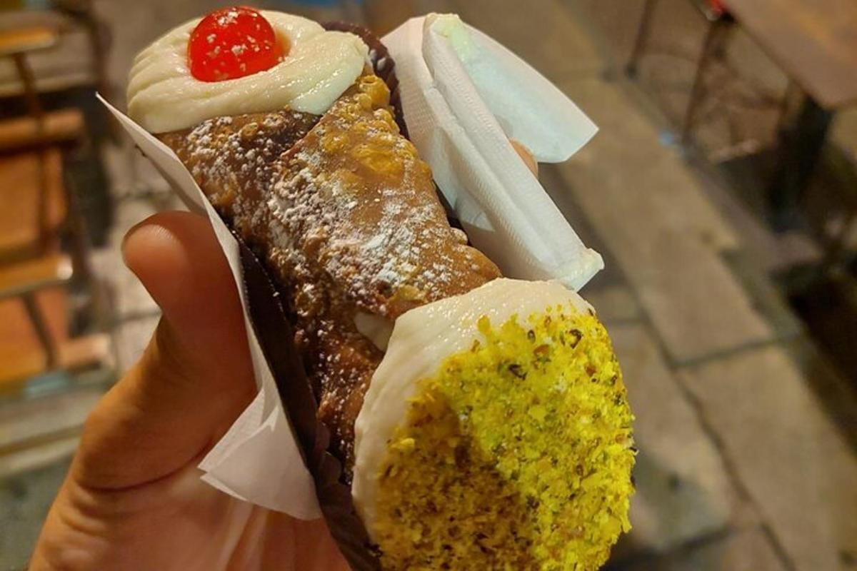 osoba držící hot dog s hořčicí a omáčkou