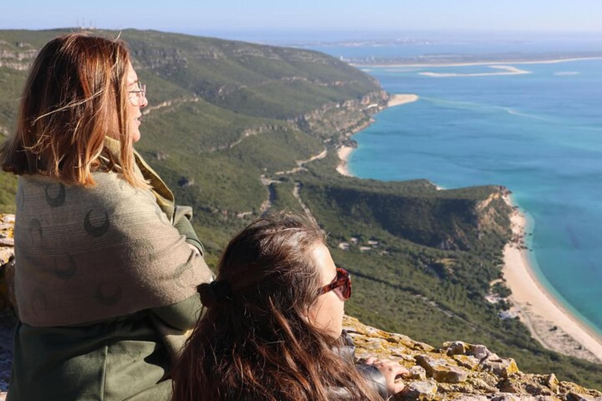 due donne sedute in cima a una montagna che domina l'oceano