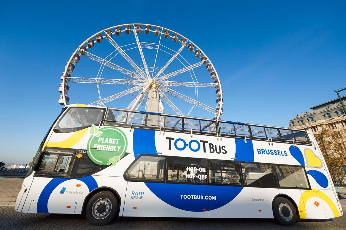 a double decker bus with a ferris wheel in the background